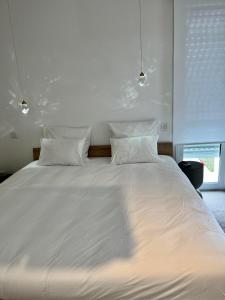 芒德Domaine de Mende Brenoux Suites & SPA的一张白色大床,配有白色床单和枕头