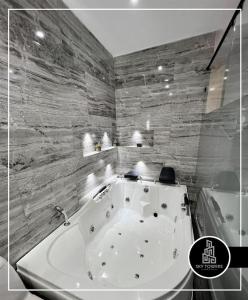 库库塔Sky Towers的带浴缸的浴室和石墙