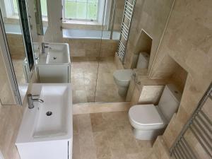 伦敦Kensington Luxury Apartments的浴室配有盥洗盆、卫生间和盥洗盆。