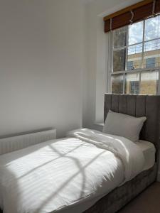 伦敦Kensington Luxury Apartments的卧室配有白色的床和窗户