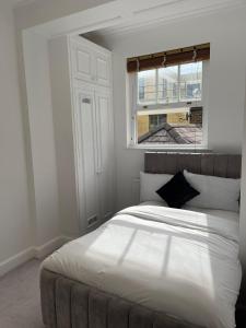 伦敦Kensington Luxury Apartments的卧室配有一张大白色床和窗户