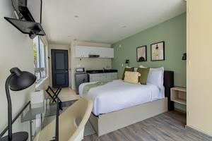 墨西哥城Capitalia - Apartments - Juan Racine的卧室设有白色的床和绿色的墙壁
