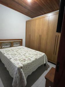 蒂拉登特斯Casa Almeida的一间卧室配有一张床和木制橱柜