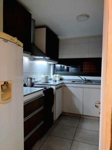 卢汉德库约Montaña Sol Malbec的厨房配有黑色橱柜和白色家电