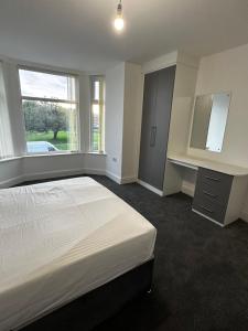 曼彻斯特OYO Cheetham Hill Guest House的白色的卧室设有一张大床和一个窗户