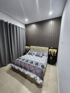 得土安Appartement Idéal : Proximité, Confort et Élégance的一间卧室设有一张床和黑色的墙壁