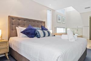曼哲拉Beachside Bliss 1 Bedroom Park View Villa的卧室配有带蓝色枕头的大型白色床