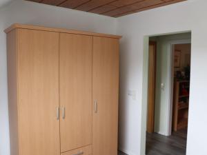 伦讷施塔特Fewo-rosenberger-sauerland的白色墙壁的房间里设有一个大型木制橱柜