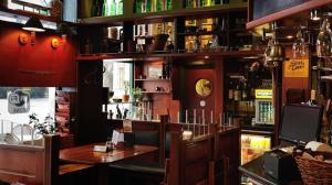 多瑙新城卡瓦哈兹角落酒店的餐厅设有酒吧,配有桌子和架子