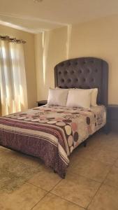 克萨尔特南戈Casa en condominio的一间卧室配有一张大床和大床头板