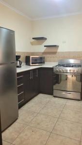 克萨尔特南戈Casa en condominio的厨房配有不锈钢冰箱和炉灶。