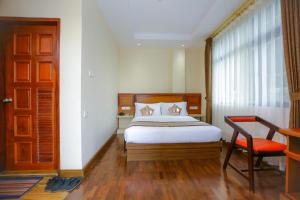 Rangoon AhloneHOTEL KEIO YANGON的卧室配有床、椅子和窗户。