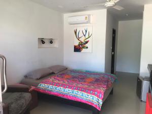拉迈Private Lodge Beachside Samui Lamai的一间卧室配有一张带五颜六色棉被的床