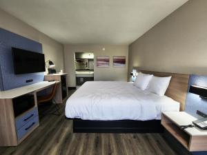 拉斐特Smart Stay Lafayette的酒店客房配有一张床、一张书桌和一台电视。