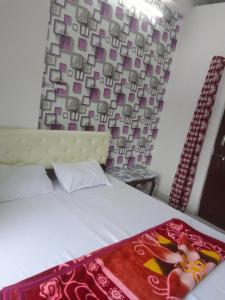 乌代浦Shree Krishna Hotel的一间卧室配有一张床铺,床上铺有红色毯子