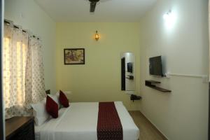 耶拉汉卡Hotel Bangalore Airport inn, Airport Pickup & Drop Available 24X7的一间卧室配有一张床和一台电视