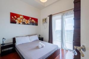 马尼拉Serviced condominium near Manila airport (NAIA)的一间卧室设有一张床和一个大窗户
