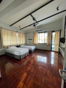 Bangkok Yaihome near MRT Tha Phra Villa sookkasem的大型客房设有两张床和木地板。