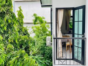 Bangkok Yaihome near MRT Tha Phra Villa sookkasem的通往带桌子的花园的开放式门