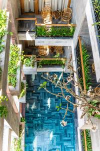 岘港Bonny Boutique Hotel Da Nang的游泳池的顶部景观,设有椅子和植物