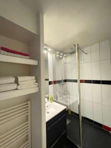 拉波勒Appartement La Baule - Plage Benoît的带淋浴、盥洗盆和浴缸的浴室