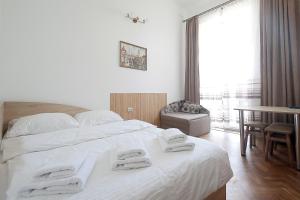 利沃夫Deluxe Apartments on Doroshenka 29的卧室配有带毛巾的大型白色床