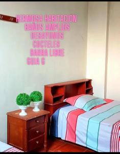 廷戈玛丽亚Garrison Alojamiento , selva y Turismo y Comida的卧室配有一张床,墙上有标志