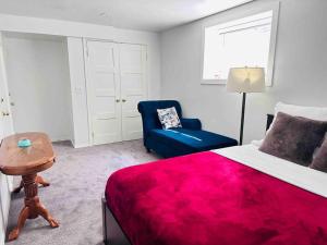 卡尔加里2 Bedrooms Private Basement Suite Close to Winsport & Downtown的一间卧室配有红色的床和蓝色椅子