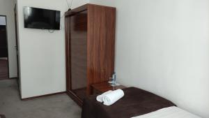 乌尔根奇Safiya hotel的酒店客房配有一张床、一台电视和一张sidx床。