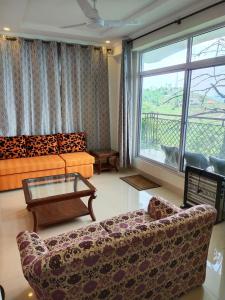 布尔班Bhurban Continental Apartment 45-F的客厅配有沙发和桌子