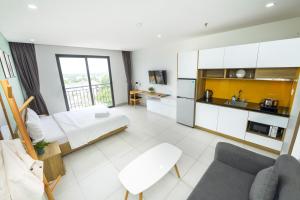 土龙木市LP rental - Minimalist Studio Apartments的配有床和厨房的大客房