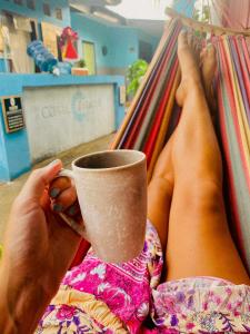 吉利特拉旺安NEW CORALs的躺在吊床上喝杯咖啡的人