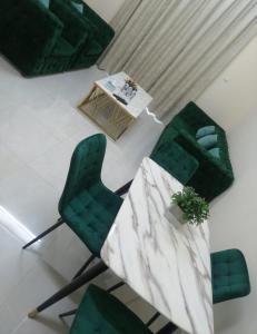 阿吉曼Al Rawda Apartments -Ajman的客厅配有绿色椅子和桌子