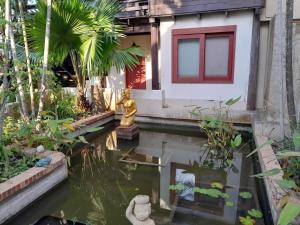 Ban Bang Krasan大城府河畔景苑酒店的花园中带锦 ⁇ 池的房屋