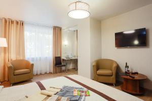 乌拉尔斯克APART-HOTEL VEGUS的酒店客房配有一张床、两把椅子和一张桌子