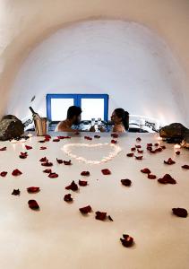 菲罗斯特法尼Rafael' s Mediteranian Cave Suites的一组玫瑰坐在桌子上