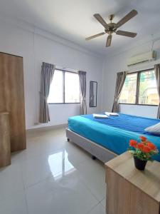 芭东海滩The Villa Residences Resort的一间卧室配有蓝色的床和吊扇