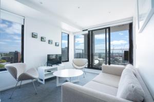 奥克兰Apartment with Brilliant views in Auckland CBD的客厅配有白色家具和大窗户