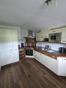克森Schroider的厨房铺有木地板,配有白色橱柜。