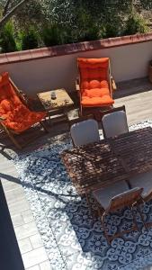 乌尔拉Semiramis Urla Guesthouse的庭院配有橙色的沙发、桌子和椅子