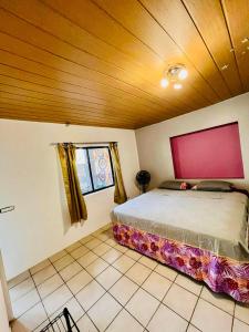 努库希瓦Chez Aniaki的一间卧室设有一张床和木制天花板