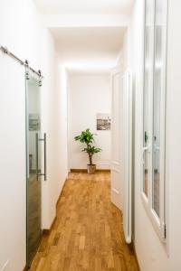 的里雅斯特Cosy Moods的走廊设有白色墙壁和硬木地板