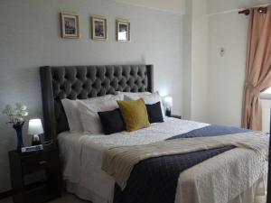 圣克鲁斯Lindo DPTO en Condominio Cama KING的一间卧室配有一张大床,提供黄色和蓝色的枕头