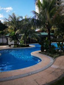 圣克鲁斯Lindo DPTO en Condominio Cama KING的度假村内棕榈树游泳池