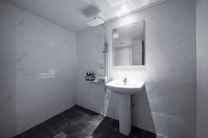 仁川市Hotel Duruwa Main Building的白色的浴室设有水槽和镜子