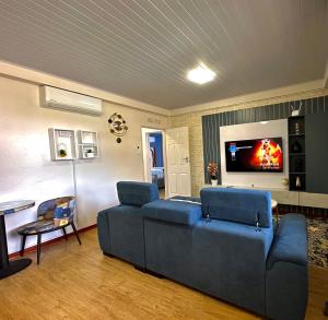 哈博罗内Exquisite short and long stay的客厅配有蓝色的沙发和电视