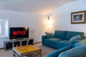 梅纳焦Casa Cometa Designer Attic Menaggio的客厅配有蓝色的沙发和电视