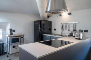 梅纳焦Casa Cometa Designer Attic Menaggio的厨房配有水槽和黑冰箱。