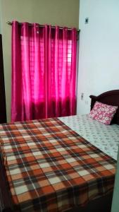 耶拉吉里Tulips Misty hights 2BHK villa的一间卧室配有一张带粉红色窗帘的床