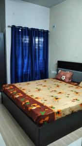 耶拉吉里Tulips Misty hights 2BHK villa的一间卧室配有一张带蓝色窗帘的大床